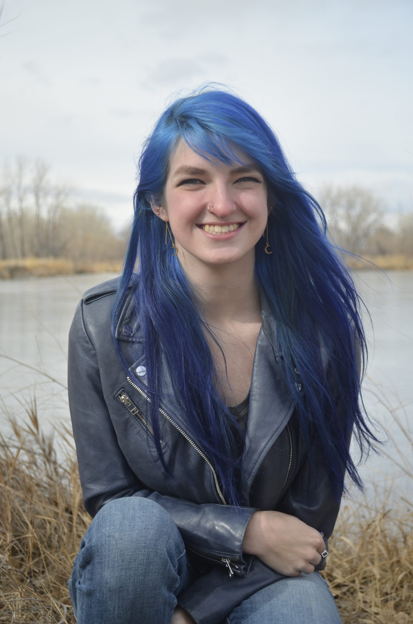 Student smiling in front of a lake